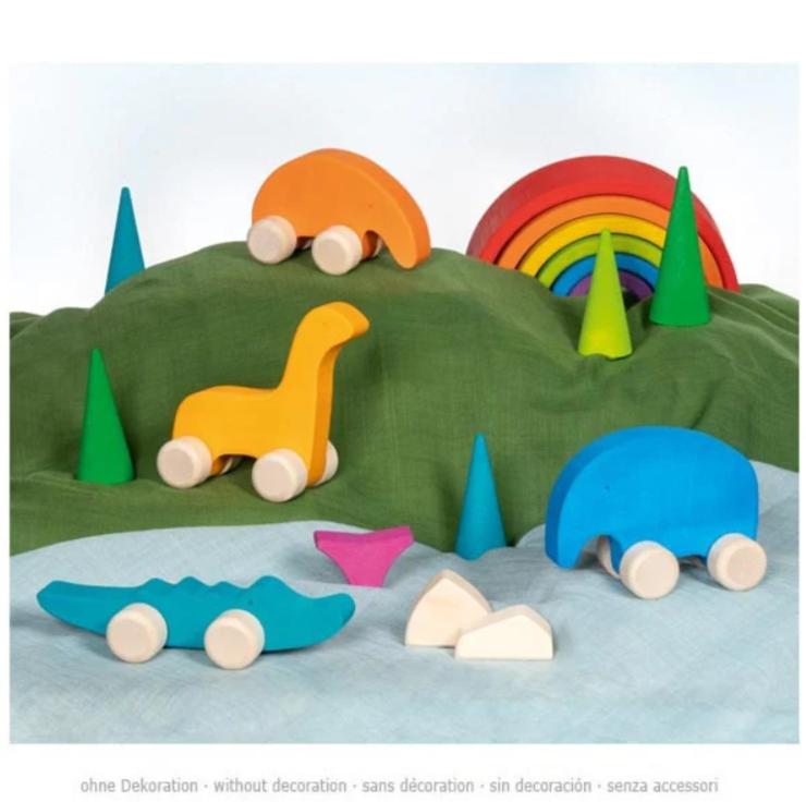 Colorful wooden toy cars on a green hill with trees and a rainbow.