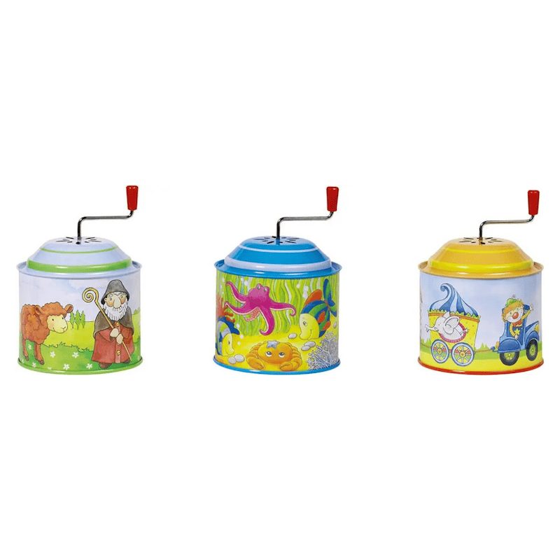 Three colorful tin music boxes with cartoon designs on a white background