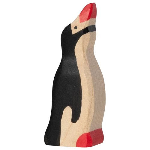 Wooden toy penguin with black body, beige belly, and red feet and beak on a white background