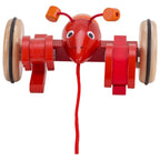 Red toy lobster with wooden wheels on a white background