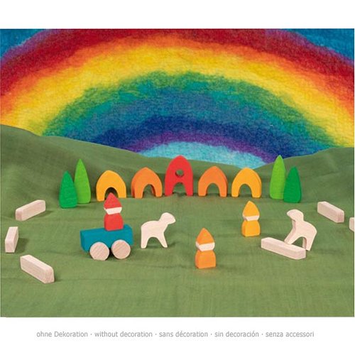 Colourful wooden toy set with houses, trees, and a rainbow on a green background