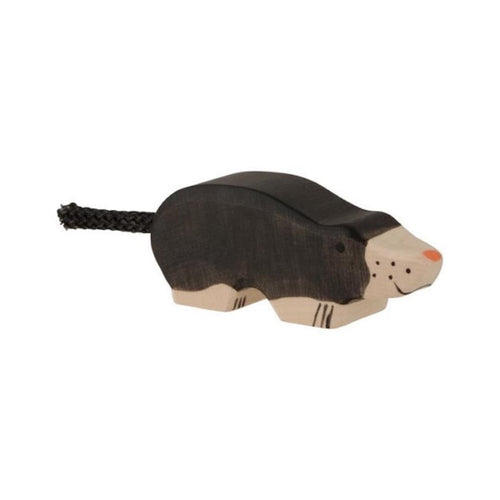 Wooden toy mole with a string tail on a white background